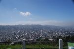Blick nach Südosten vom Panecillo Hügel aus. Links am Horizont der Vulkan Sincholagua, mittig der gletscherbedeckte Gipfel des Vulkans Cotopaxi und rechts der Vulkan Illiniza.